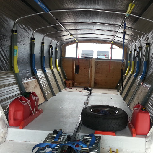 Interior with fuel storage, bike racks, spare tire, tools ramps, etc.

Complete trailer weighs less than 2000 pounds. 15 inch wheels, hydraulic surge brakes, torsion bar suspension, adjustable axle location, galvanized frame.