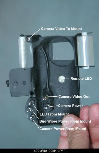 The back of the Bug Wiper showing electrical contacts and the infrared LCD positioned to control most camera functions