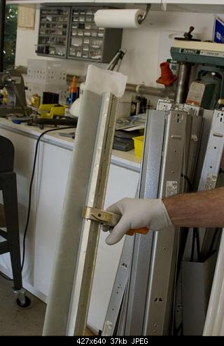 The Fairing Clamped to cure.  This holds the peel ply covered glass lay-up tight to the plug mold without need for vacuum bagging.